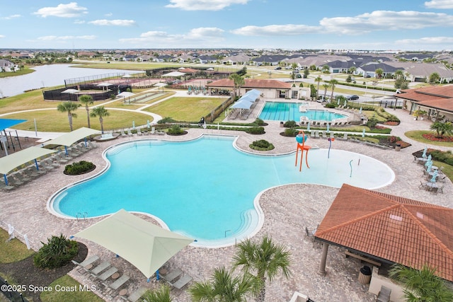 view of pool featuring a water view and a patio