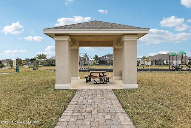 view of community featuring a lawn, a gazebo, a patio area, and a playground