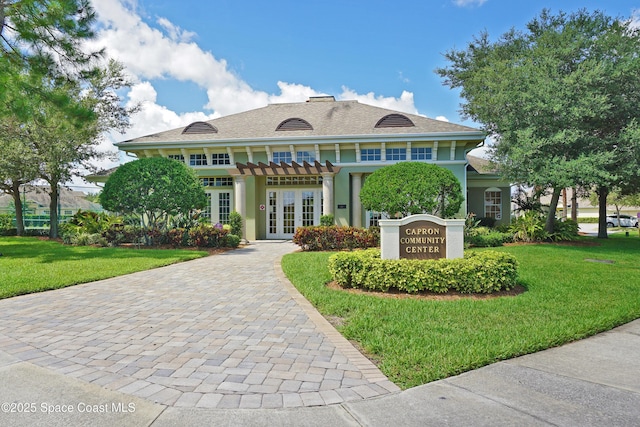 view of front of property with a front yard and french doors