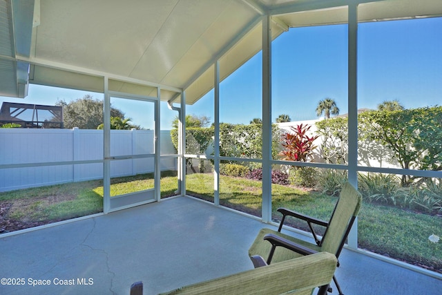 unfurnished sunroom featuring vaulted ceiling and a wealth of natural light