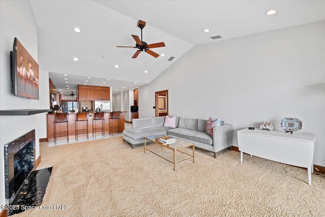 living room featuring light carpet, high vaulted ceiling, and ceiling fan