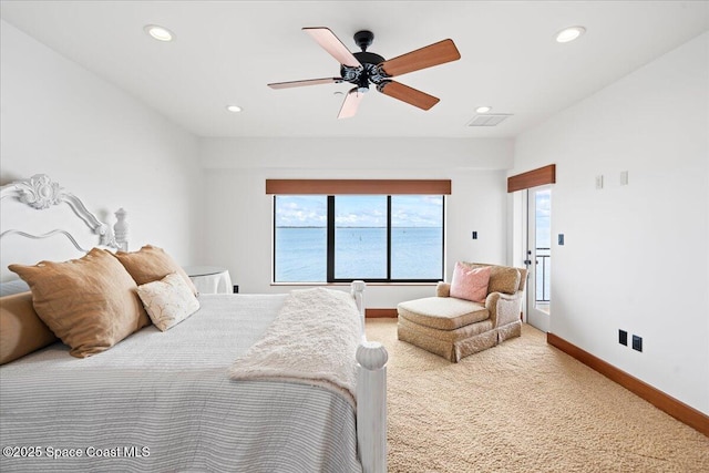 carpeted bedroom with ceiling fan and a water view