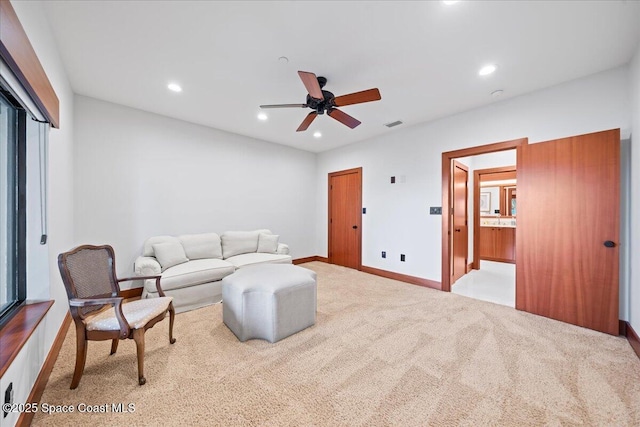 carpeted living room with ceiling fan