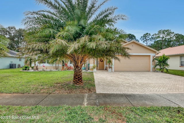 view of front of property featuring a front yard, a garage, and central AC