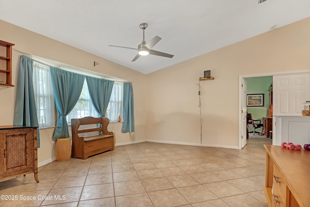 living area with light tile patterned flooring, ceiling fan, and vaulted ceiling