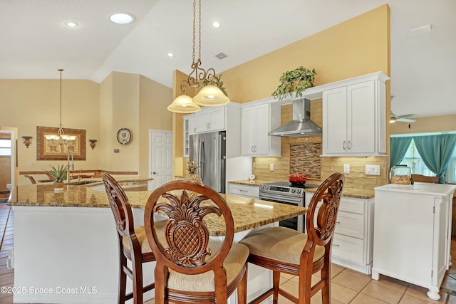 kitchen featuring stainless steel appliances, wall chimney exhaust hood, backsplash, a kitchen island, and pendant lighting