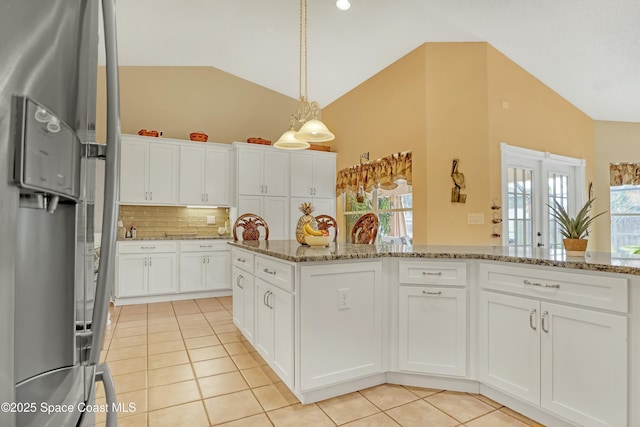 kitchen with white cabinets, stone countertops, decorative backsplash, and light tile patterned floors