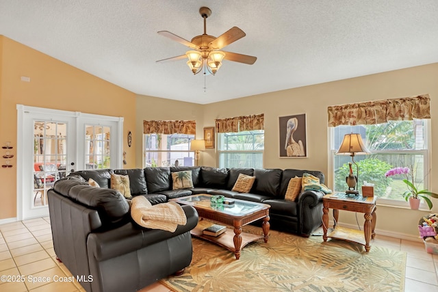 living room featuring lofted ceiling, a textured ceiling, ceiling fan, and light tile patterned flooring