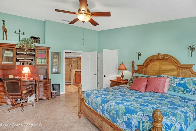 bedroom featuring ensuite bath, a textured ceiling, light tile patterned flooring, and ceiling fan