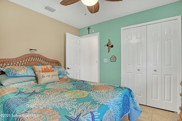 bedroom featuring ceiling fan, light tile patterned floors, and a closet