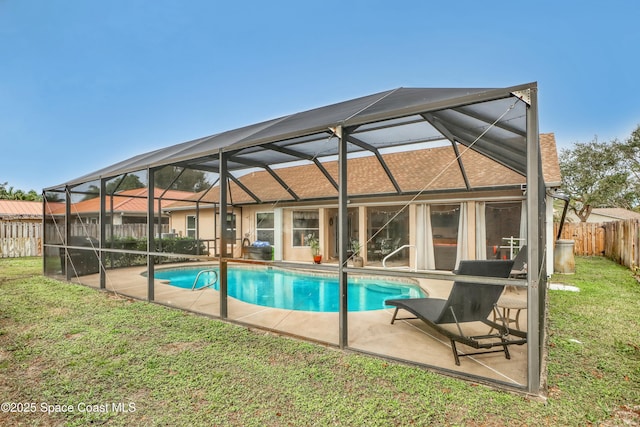 view of swimming pool featuring a lawn, a patio area, and glass enclosure