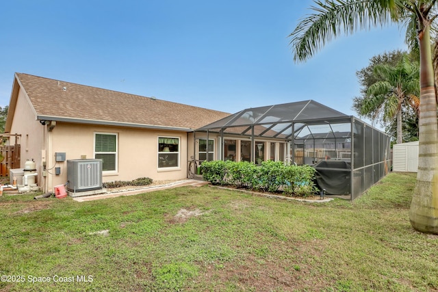 back of house featuring a lanai, central air condition unit, and a yard