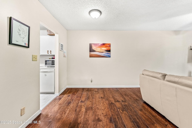 unfurnished living room featuring dark hardwood / wood-style flooring and a textured ceiling