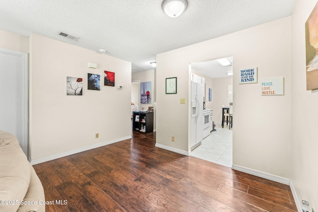 unfurnished room featuring hardwood / wood-style flooring and a textured ceiling