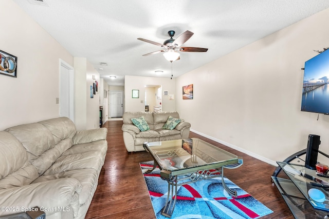 living room with a textured ceiling, dark hardwood / wood-style floors, and ceiling fan