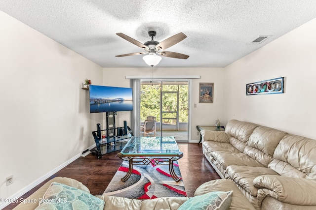 living room with a textured ceiling, ceiling fan, and dark hardwood / wood-style floors