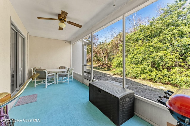 unfurnished sunroom with ceiling fan