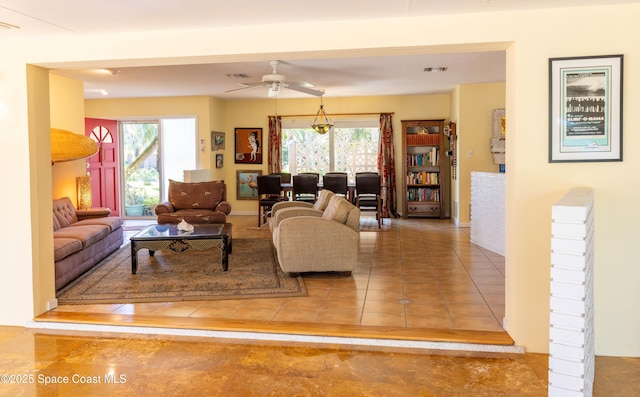 tiled living room featuring a ceiling fan, visible vents, and a healthy amount of sunlight