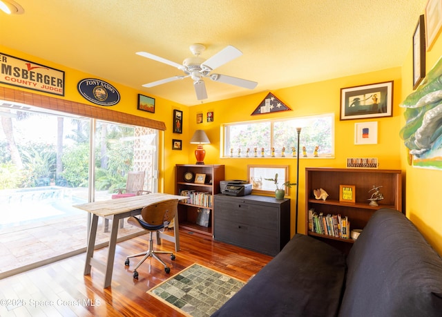 office with a textured ceiling, wood finished floors, and a ceiling fan