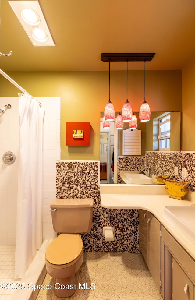 bathroom featuring vanity, a shower stall, and toilet