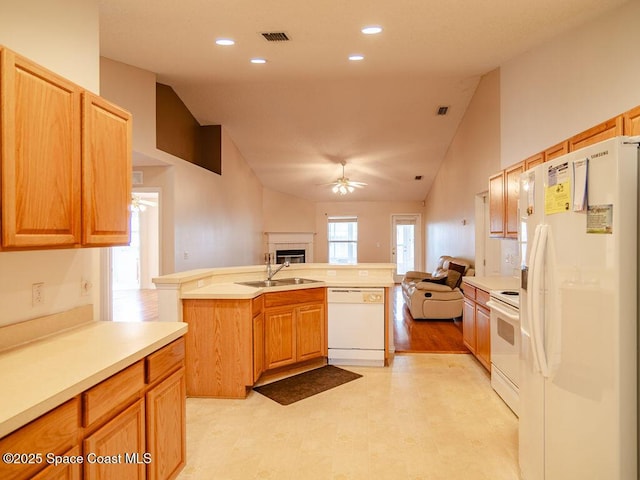 kitchen with white appliances, vaulted ceiling, an island with sink, ceiling fan, and sink