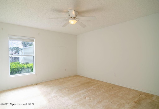 carpeted empty room featuring ceiling fan and a textured ceiling