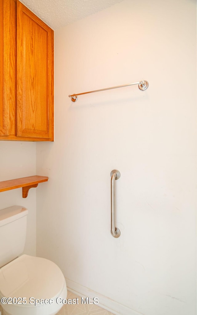 bathroom with toilet and a textured ceiling