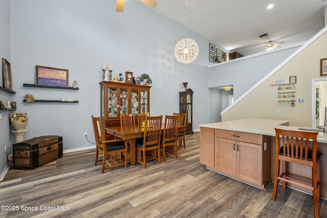 dining space with sink, dark wood-type flooring, vaulted ceiling, and ceiling fan