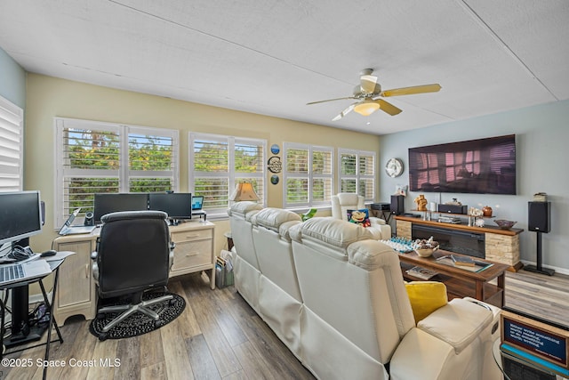 living room featuring ceiling fan, a textured ceiling, and dark hardwood / wood-style flooring