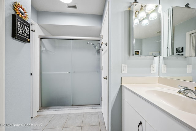 bathroom featuring vanity, walk in shower, and tile patterned flooring