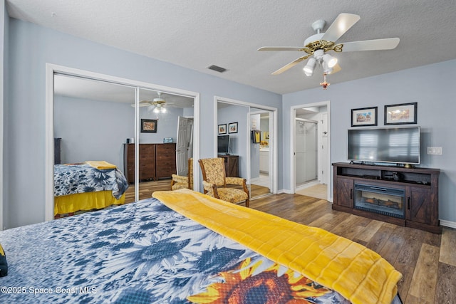 bedroom featuring ceiling fan, wood-type flooring, and a textured ceiling