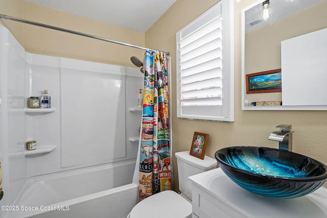 full bathroom featuring sink, a textured ceiling, toilet, and shower / bath combo