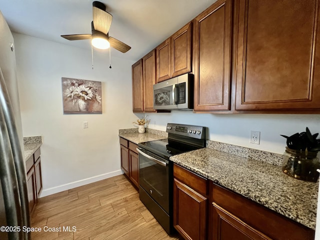 kitchen with electric range, light hardwood / wood-style flooring, ceiling fan, and light stone counters