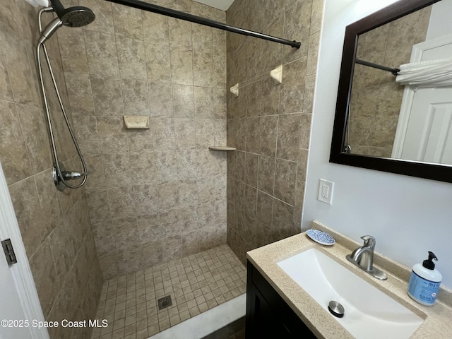 bathroom featuring a tile shower and vanity