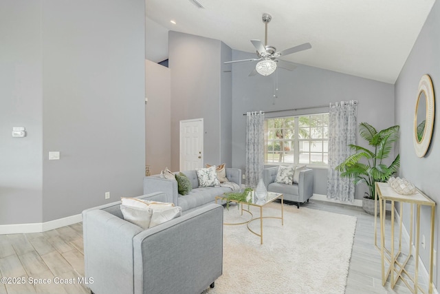 living room with high vaulted ceiling, ceiling fan, and light hardwood / wood-style flooring