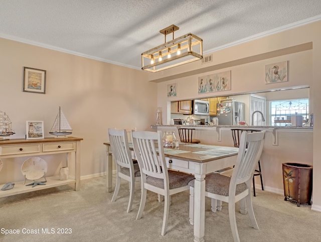 carpeted dining space with a textured ceiling, crown molding, and sink