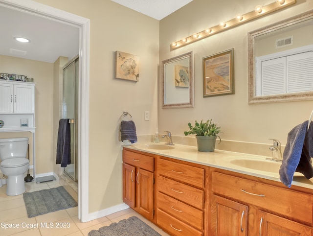 bathroom featuring tile patterned flooring, vanity, an enclosed shower, and toilet