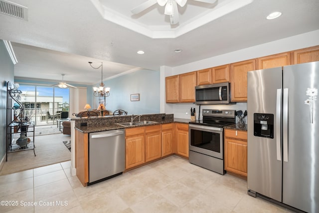 kitchen with stainless steel appliances, dark stone countertops, sink, hanging light fixtures, and kitchen peninsula