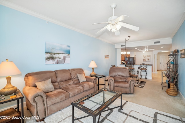 living room featuring ceiling fan with notable chandelier, crown molding, and light carpet