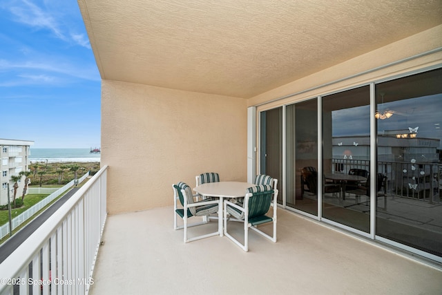 balcony featuring a water view and a view of the beach