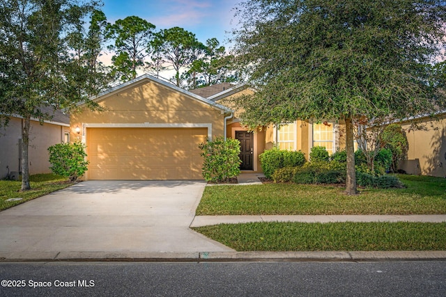 view of front of property with a garage and a yard