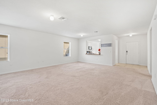 unfurnished living room with light colored carpet