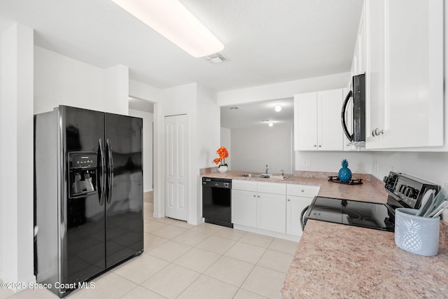 kitchen with sink, light tile patterned flooring, black appliances, and white cabinetry