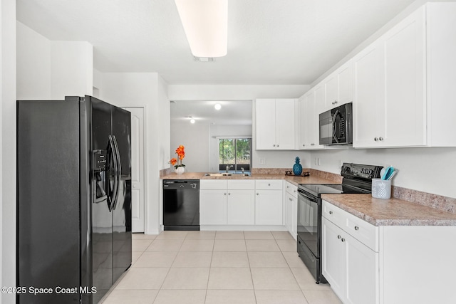 kitchen with black appliances, white cabinetry, sink, and light tile patterned flooring