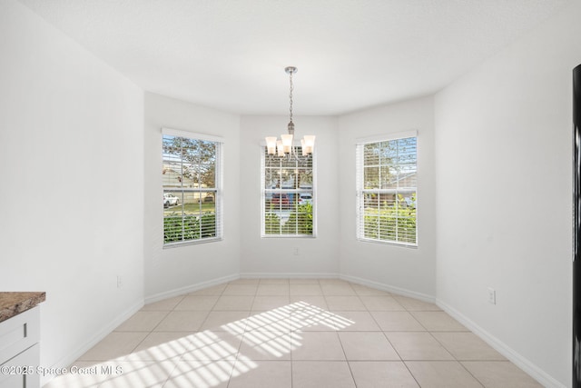 unfurnished dining area featuring an inviting chandelier and light tile patterned floors