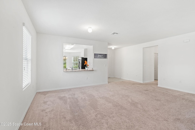 carpeted empty room with a healthy amount of sunlight