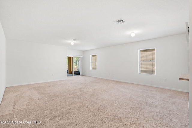 unfurnished room featuring light carpet