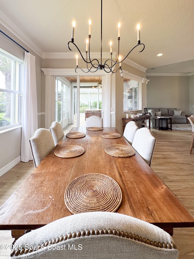 dining area with ornamental molding, a textured ceiling, and light wood-type flooring