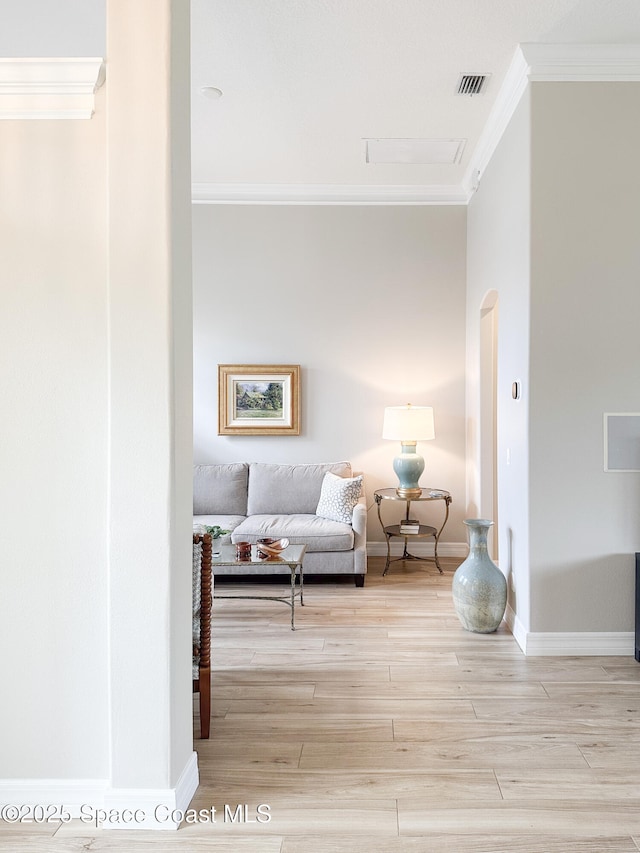 hallway with ornamental molding and light wood-type flooring