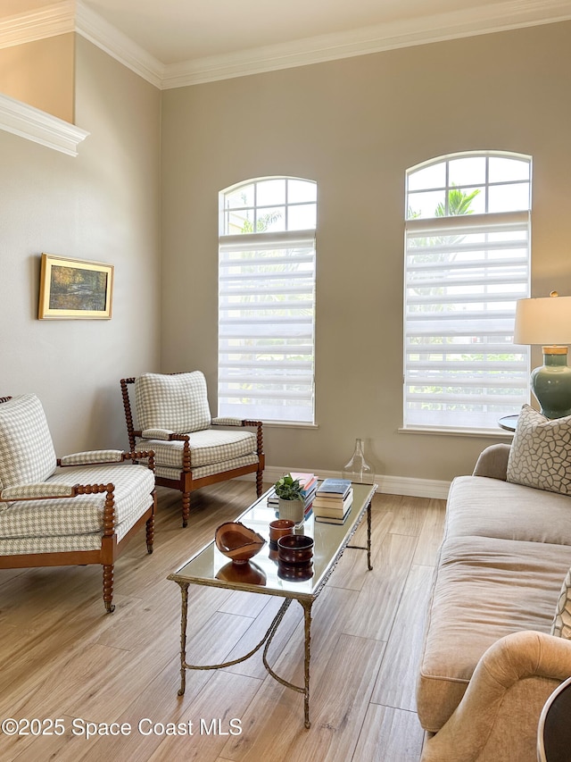 living room with crown molding, plenty of natural light, and light wood-type flooring